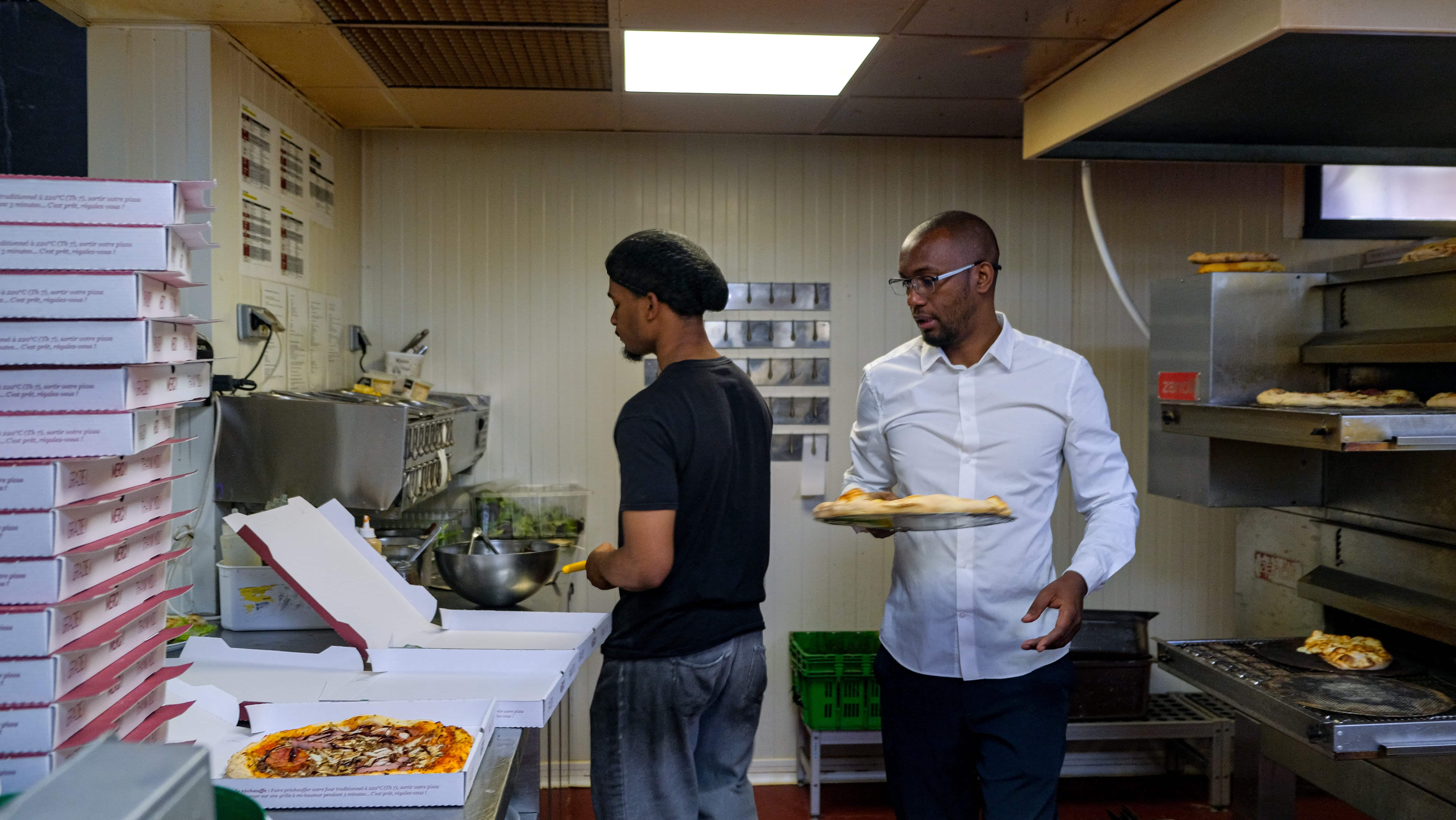 Formateur épaulant l'équipe en cuisine pendant le service