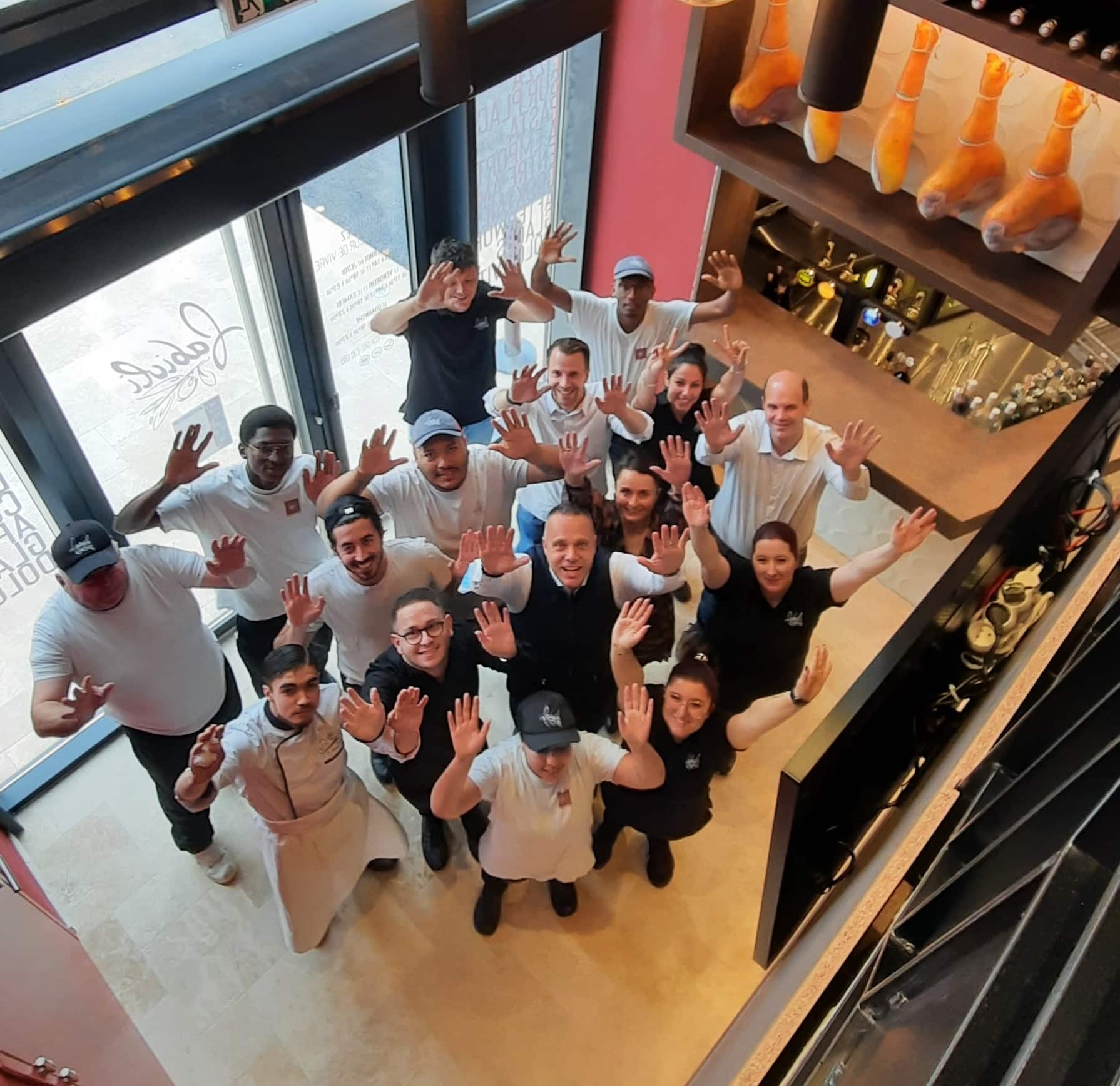 Toute l'équipe Fabioli réunie dans le restaurant, bras levés