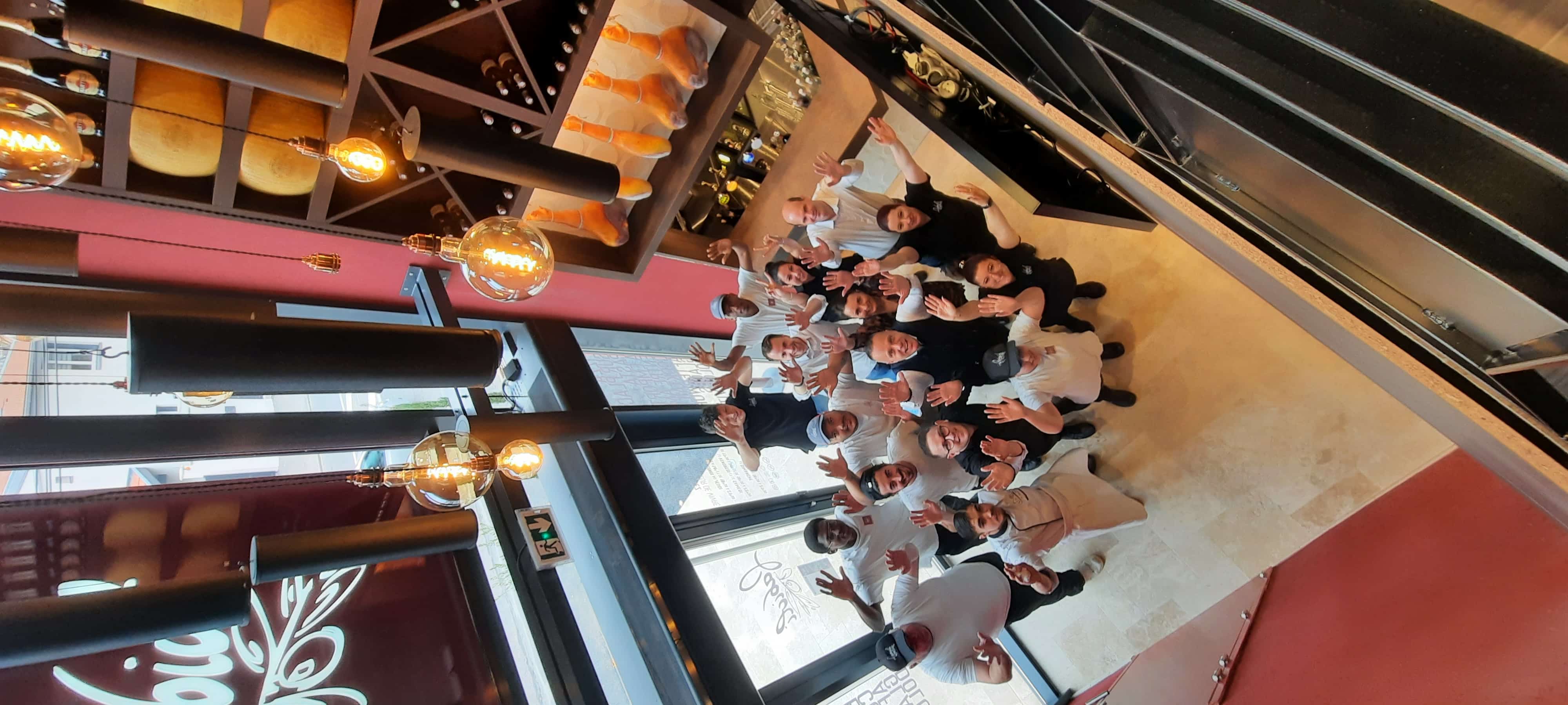 Équipe Fabioli réunie, bras levés dans le restaurant