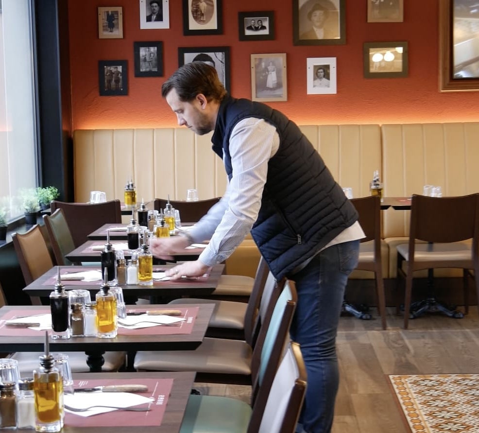 Maxime, franchisé Fabioli Villeurbanne, dressant une table en salle