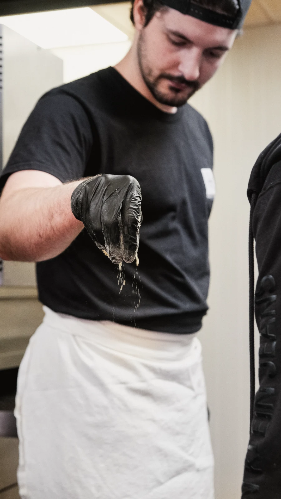 Cuisinier Fabioli farinant la pâte au poste de travail