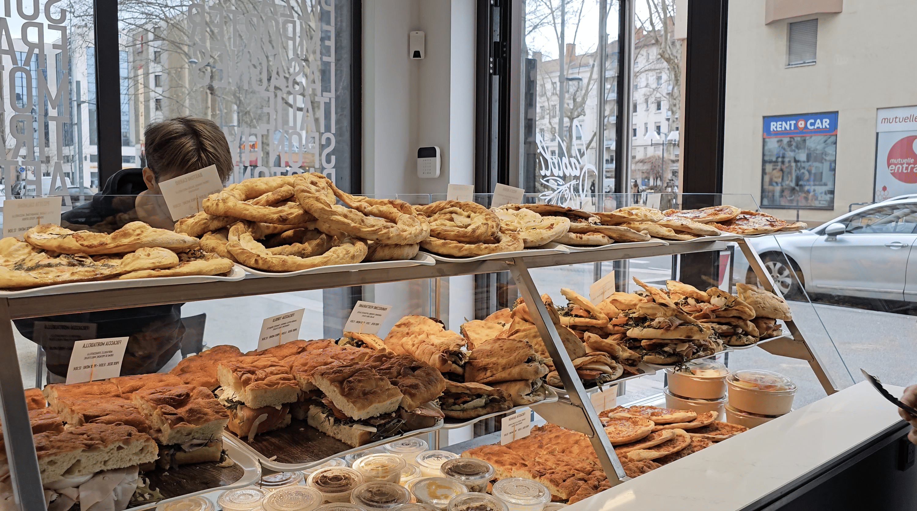 Vitrine Fabioli Presto : bastoni en couronne, focaccie et panuozzi sur le comptoir