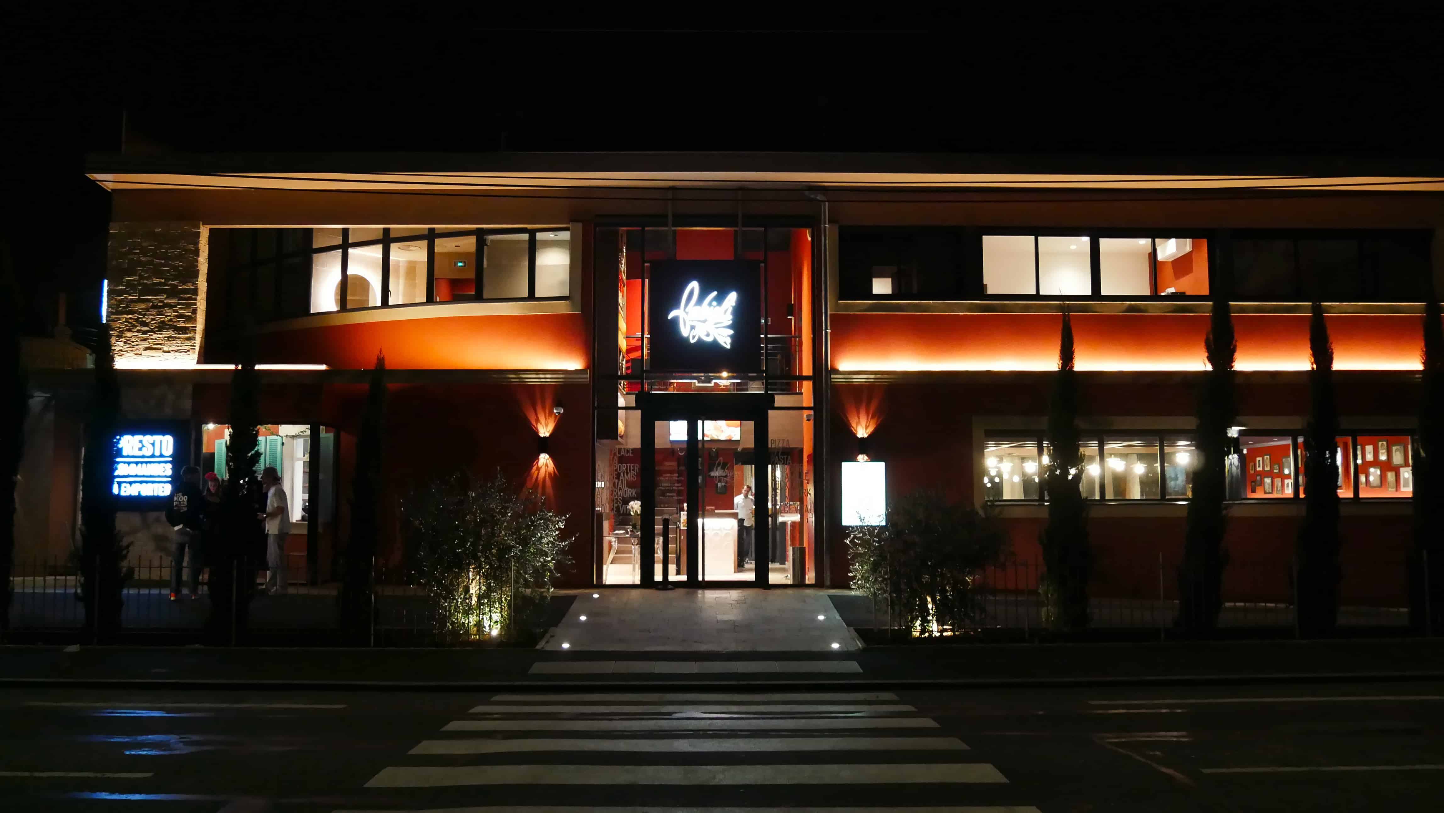 Façade illuminée d'un restaurant Fabioli à la tombée de la nuit